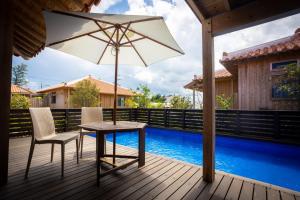 a table and two chairs and an umbrella on a deck at Villa Muse Okinawa- Vacation STAY 43816v in Nago