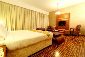 a hotel room with a bed and a living room at St Laurn The Spiritual Resort in Shirdi