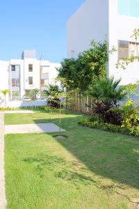 a yard with grass and trees in front of a building at Blue Sea Vallarta - Relax, Explore and Enjoy! in Los Algodones