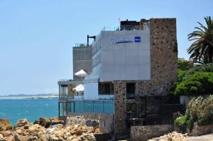 a building with a nautilus sign on it next to the ocean at Radisson Blu Acqua Hotel & Spa Concon in Concón