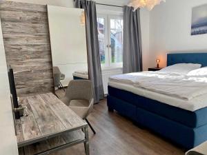 a bedroom with a bed and a table and a chair at FeWoWa _ FerienWohnungen Walter in Bad Sachsa