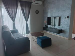 a living room with a couch and a tv at Alanis Comfort Zone KLIA TRANSIT in Kampong Bekoh