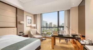 Una habitación de hotel con una cama, un escritorio y una ventana. en Jin Jiang Mingcheng Hotel, en Yancheng 256 fotos más