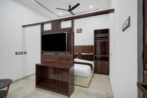 バラナシにあるSuper Collection O Banaras Railway Junction Formerly Varanasi Suitesのベッドと薄型テレビのある寝室
