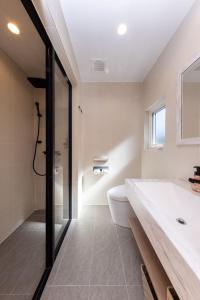 a bathroom with a tub and a toilet and a sink at Hakuba Mitsuki Chalet in Hakuba