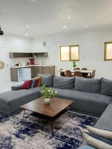 a living room with a couch and a table at شقة مفروشه ومريحة وقريبه من المناطق السياحية عوائل فقط in Al Hulaylah