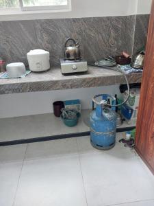 ein Küchenregal mit Geschirr und einem Teekessel darauf in der Unterkunft River Line -Ella in Ella + 25 Fotos