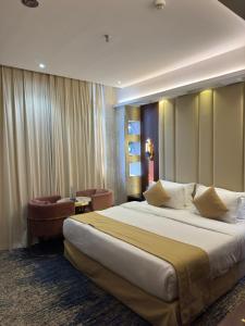 a hotel room with a large bed and chairs at Sparrow Apartments Hotel in Jeddah +43 photos