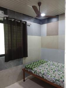 a bedroom with a bed and a ceiling fan at Sahil Bed and Breakfast in Alibag