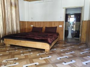een bed in een kamer met een houten vloer bij Shangarh JC Snow Valley in Shangarh