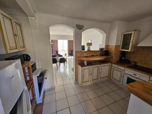 eine Küche mit weißen Fliesenböden und zwei Torbögen in der Unterkunft T2 CARRY LE ROUET CENTRE VILLE PROCHE DE LA MER in Carry-le-Rouet