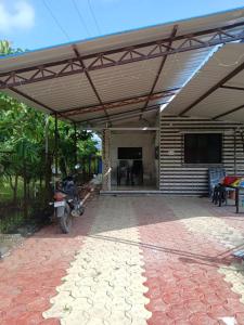 a covered patio with a television and a motorcycle parked under it at Sahil Bed and Breakfast in Alibag