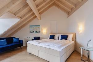 a bedroom with a large bed and a blue couch at Rössli Hurden in Hurden +41 photos