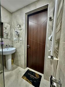 a bathroom with a sink and a wooden door at Snow Forest ԲԱԿՈՒՐԻԱՆԻ-ბაკურიანი-BAKURIANI in Bakuriani