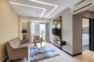a living room with a couch and a tv at Fairview Hotel by ARTOTEL in Jakarta