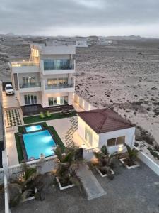 a house on the beach with a swimming pool at شالية ماربيا الاشخرة Marbella Ashkhara Chalet in Al Ashkharah