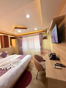 a hotel room with a bed and a desk at Airport Hotel Link Asia in Bākhri Kharka