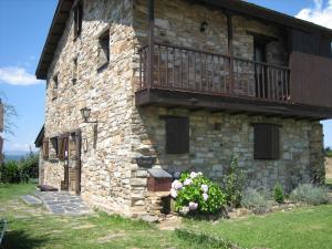 ein Steingebäude mit Balkon darüber in der Unterkunft El Mirador de las Candelas in Linarejos