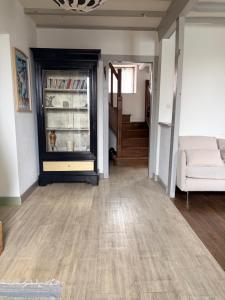 Maison pittoresque et cozy في Bonnat: غرفة معيشة مع أريكة ورف كتاب