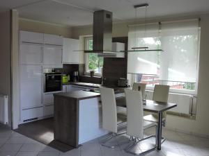 a kitchen with white cabinets and a table and chairs at Ferienwohnung Marquardt mit Wallbox in Boltenhagen