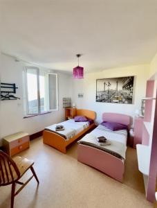 a room with two beds and a table at les chaussons d'arlequine in Dompierre-sur-Besbre