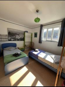 a bedroom with two beds and two windows at les chaussons d'arlequine in Dompierre-sur-Besbre