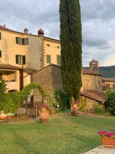 Agriturismo La Fenice في كاستيجليون فيورنتينو: مبنى كبير به أشجار ومزهريات في فناء