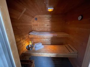 a wooden sauna with a bed and towels in it at Ferienhaus am Dürrbachtal in Unterleinleiter