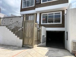 un bâtiment avec un garage doté d'une grande porte en bois dans l'établissement Apto 102 - Encantador y Amplio - Tipo Loft - Casa Orquídeas, à Fusagasuga
