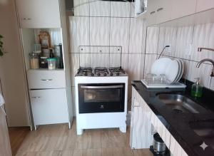een kleine keuken met een fornuis en een spoelbak bij Casa da família Neri - 130 in Belém