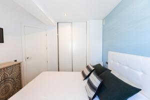 1 dormitorio con 1 cama blanca y armarios blancos en Front line beach location with stunning ocean view, en Ifach