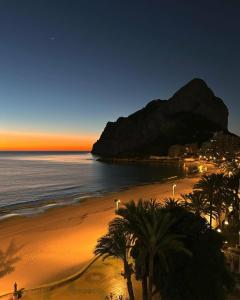 Una playa con palmeras y el océano al atardecer en Front line beach location with stunning ocean view, en Ifach