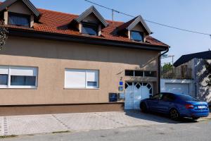 a blue car parked in front of a house at i'm at the loft in Osijek