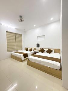 two beds in a bedroom with white walls at Green Hotel Cao Bằng in Cao Bằng