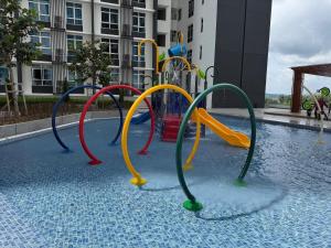 ein Spielplatz in einem Gebäude mit einem Pool in der Unterkunft Family-Friendly 3BR Stay I MIRAI Residence, Kajang 2 in Kajang