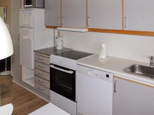 a white kitchen with a stove and a sink at 6 person holiday home in Aabenraa in Aabenraa +16 photos