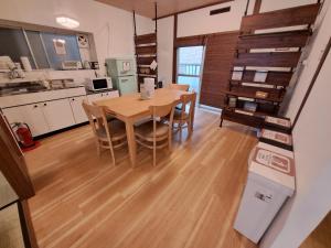 a kitchen and dining room with a table and chairs at Out of Office Hostel by 旅路 in Fukuoka