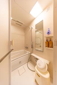 een badkamer met een bad, een toilet en een wastafel bij 真栄田岬グランブルー 104 in Onna