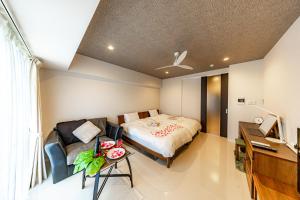 een slaapkamer met een bed en een bureau en een bureau bij 真栄田岬グランブルー 104 in Onna