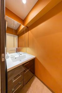 een badkamer met een wastafel en een spiegel bij 真栄田岬グランブルー 104 in Onna +52 foto's