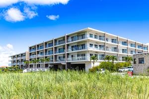 een appartementencomplex op het strand met hoog gras bij 真栄田岬グランブルー 104 in Onna