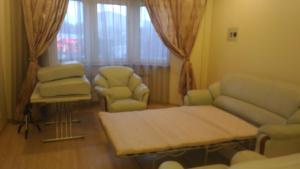 モスクワにあるKakhovka 18/1 Apartmentのリビングルーム(ソファ、テーブル、椅子付)