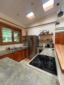 a kitchen with a stove and a stainless steel refrigerator at Zen Mountain Escape 3BR Getaway near Chirripó in Rivas