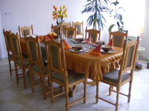 uma mesa de jantar e cadeiras com uma toalha de mesa amarela em Tünde Vendégház em Bernecebaráti