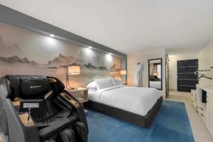 a hotel room with a bed and a couch in it at Blue - A Modern Hotel, an Ascend Collection Hotel in West Springfield