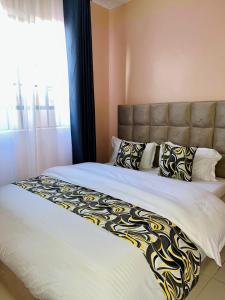 a bedroom with a large bed with a large window at Fibi Embu Apartments in Embu