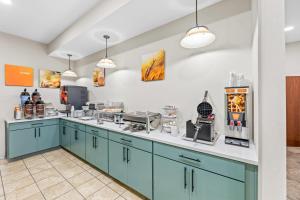 a kitchen with blue cabinets and a counter top at Comfort Suites Gothenburg South in Gothenburg
