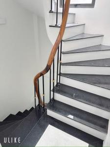 eine Treppe mit einem hölzernen Handlauf neben einer Wand in der Unterkunft House ĐDT in Hanoi + 5 Fotos