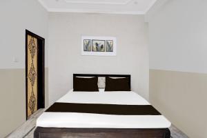 Schlafzimmer mit einem großen Bett mit schwarzweißer Bettwäsche in der Unterkunft Hotel O N Nature Green in Noida