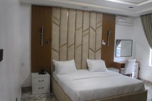 a bedroom with a large white bed and a desk at Grabbo Luxury Apartments in Gwarinpa +18 photos